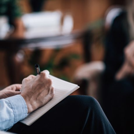 Psychiatry - Psychiatrist with unrecognizable patient, talking, taking notes